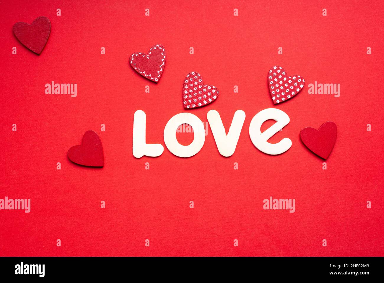 the word love on red background with small red hearts for valentines day Stock Photo