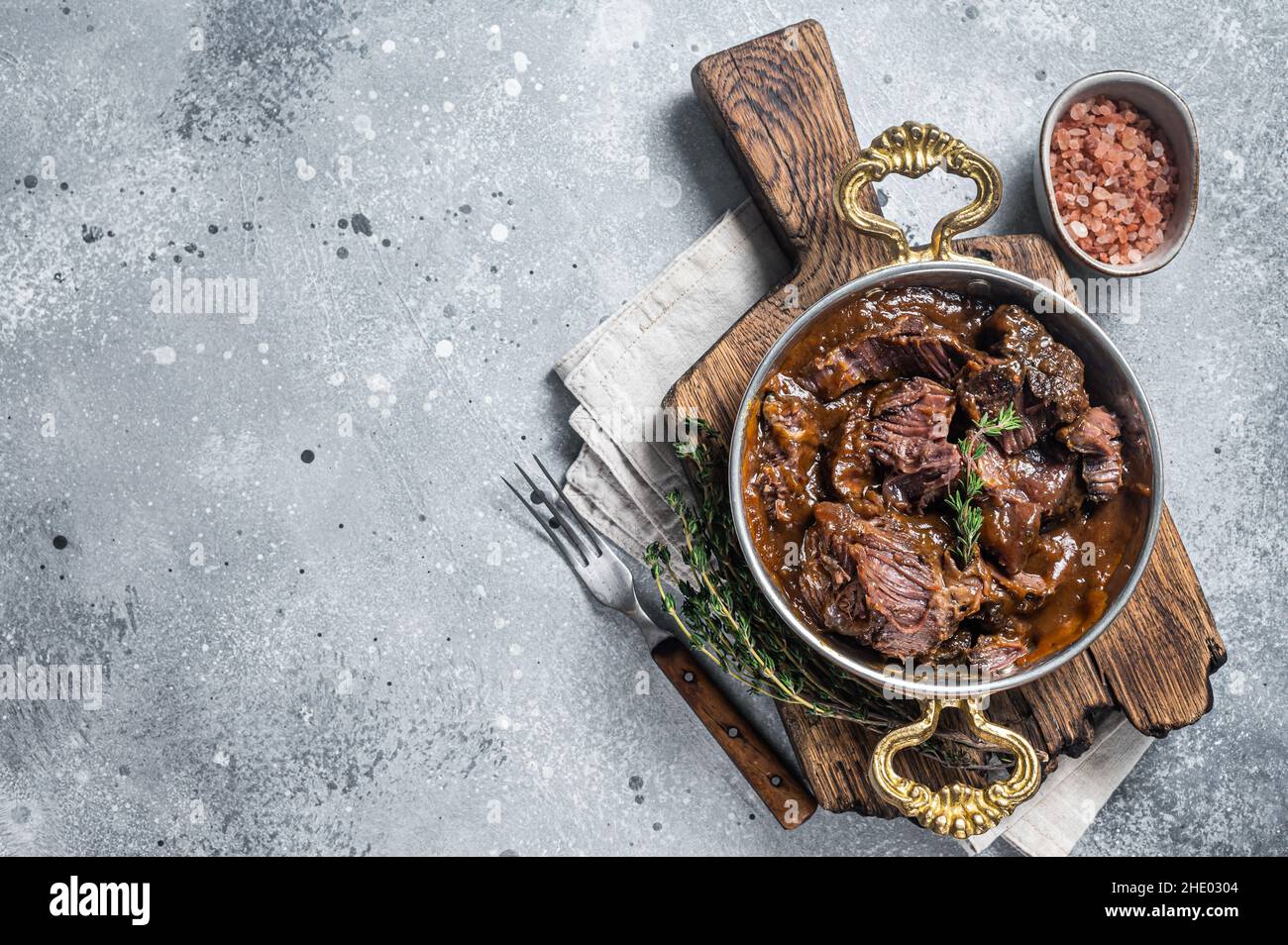 German braised beef cheeks in brown red wine sauce. Gray background