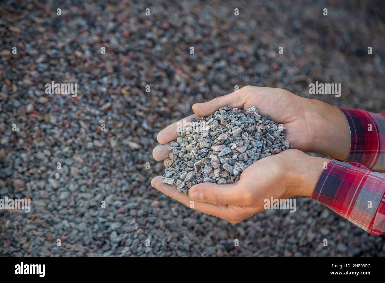 Crushed stone quarry in the hands of a man. Selective focus. Stock Photo