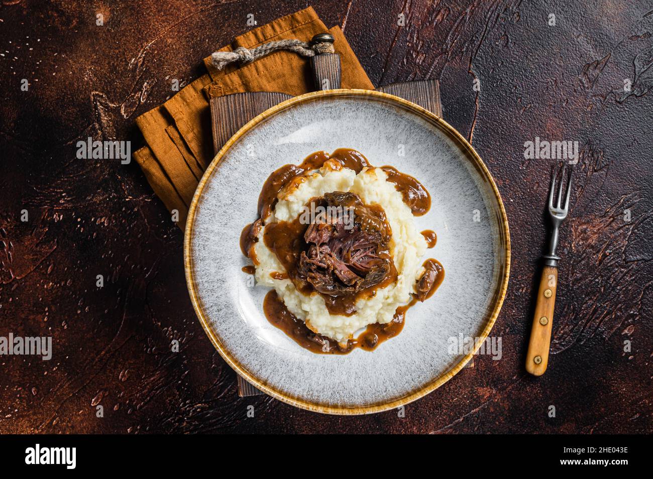 Slow cooked beef cheeks in red wine sauce with mashed potato. Dark