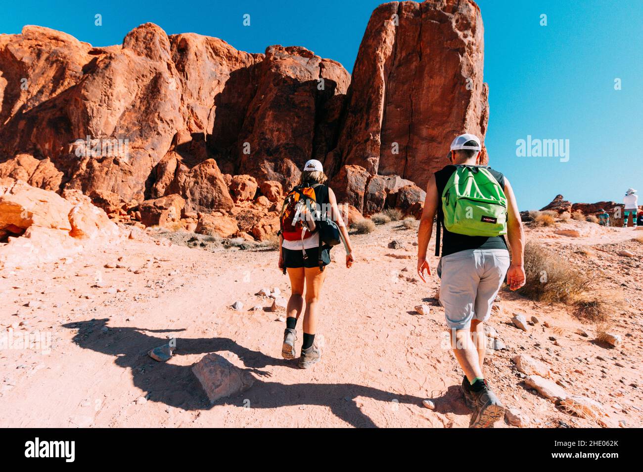Scenic shot of two hikers walking on a stone hill in the Valley of Fire ...