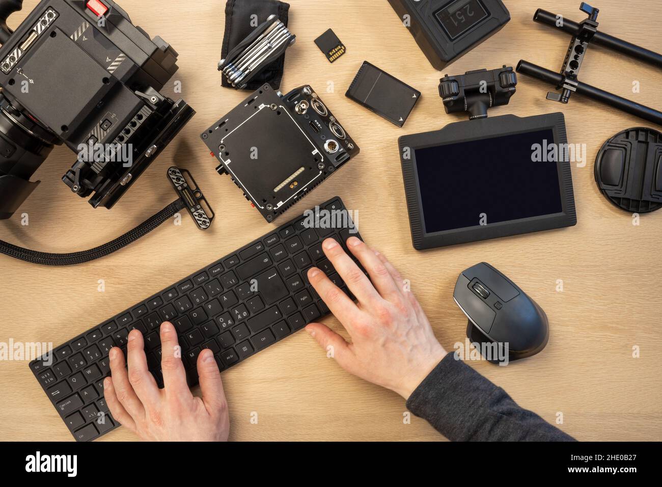 Creative photographer using computer keyboard by filming equipment at table Stock Photo