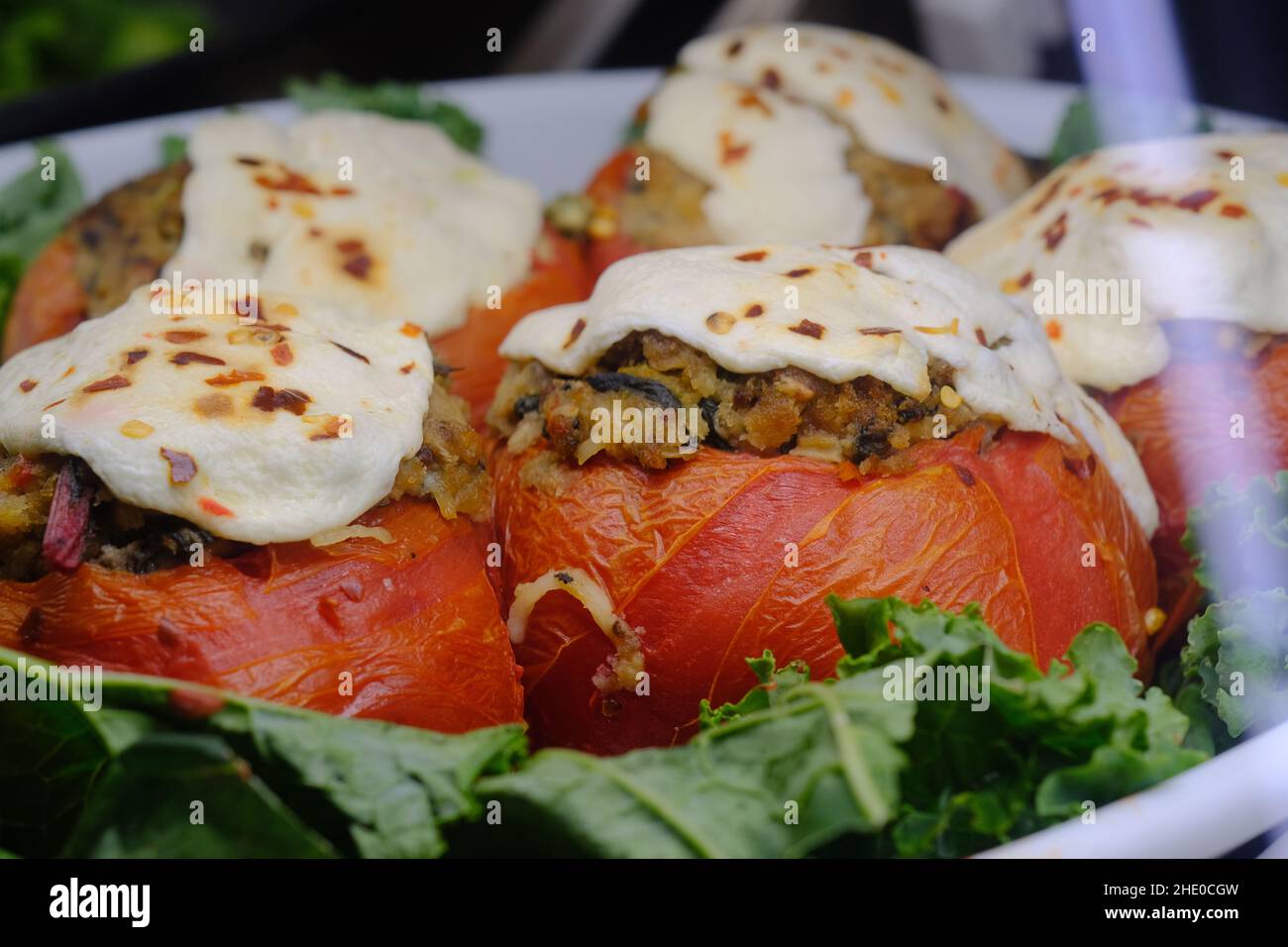 Stuffed tomatoes with mozzarella cheese on display at local deli Stock Photo