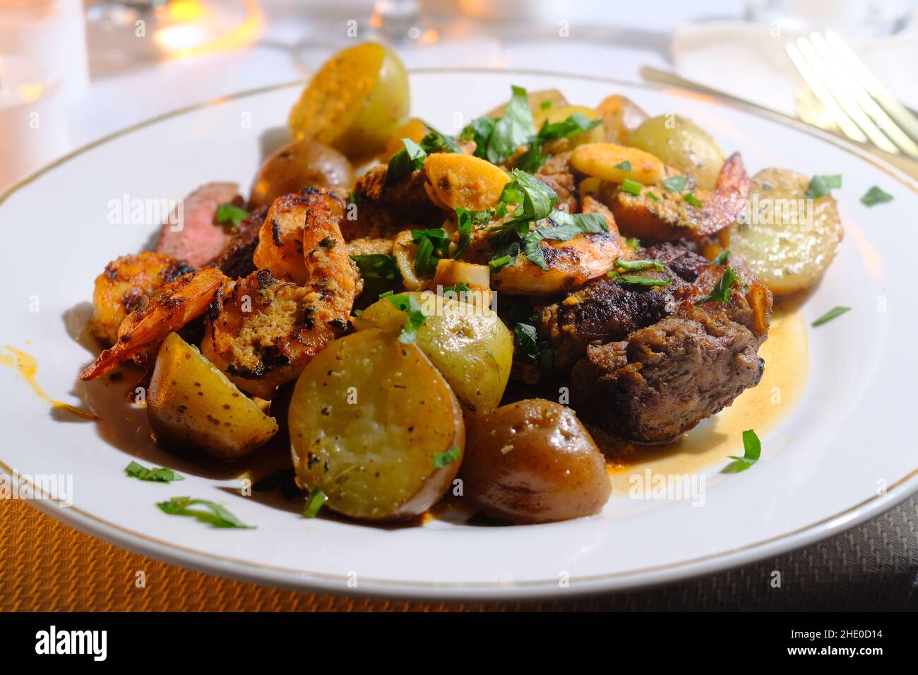 Gourmet surf and turf cajun shrimp and steak dinner entree with new potatoes at a fancy expensive wedding Stock Photo