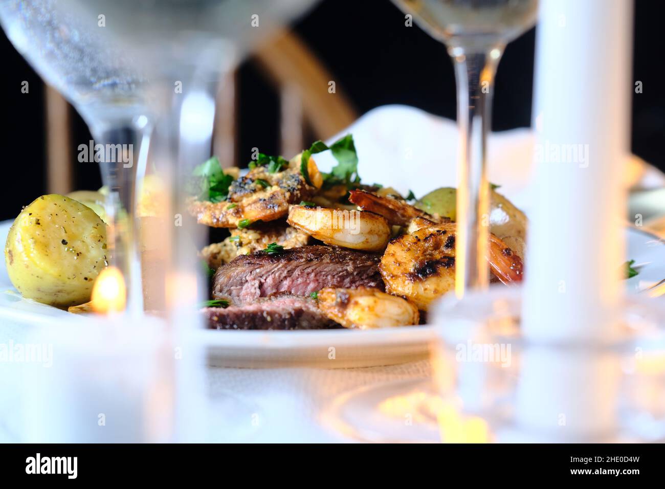 Gourmet surf and turf cajun shrimp and steak dinner entree with new potatoes at a fancy expensive wedding Stock Photo