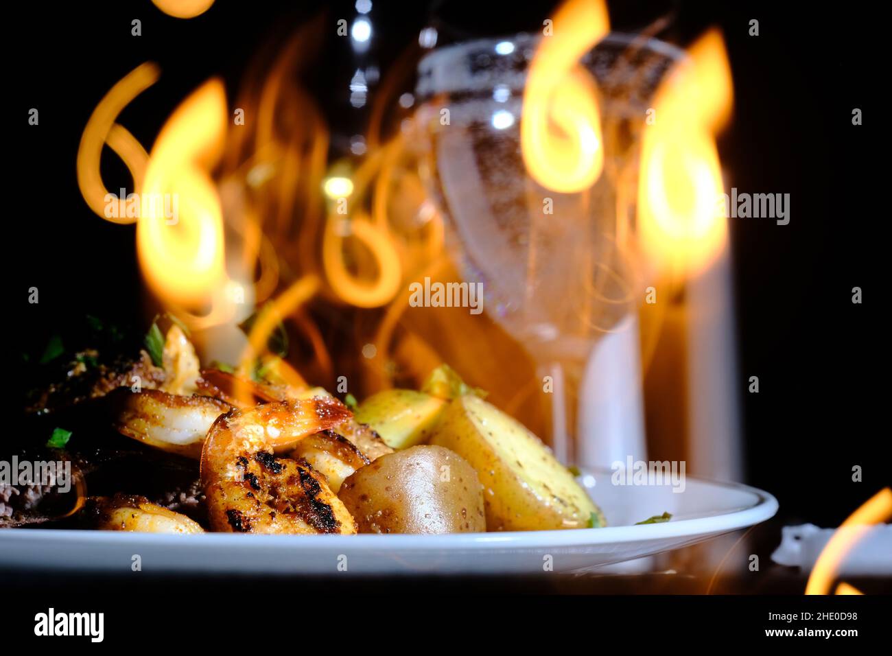 Gourmet surf and turf cajun shrimp and steak dinner entree with new potatoes at a fancy expensive wedding with number 6 background blur Stock Photo