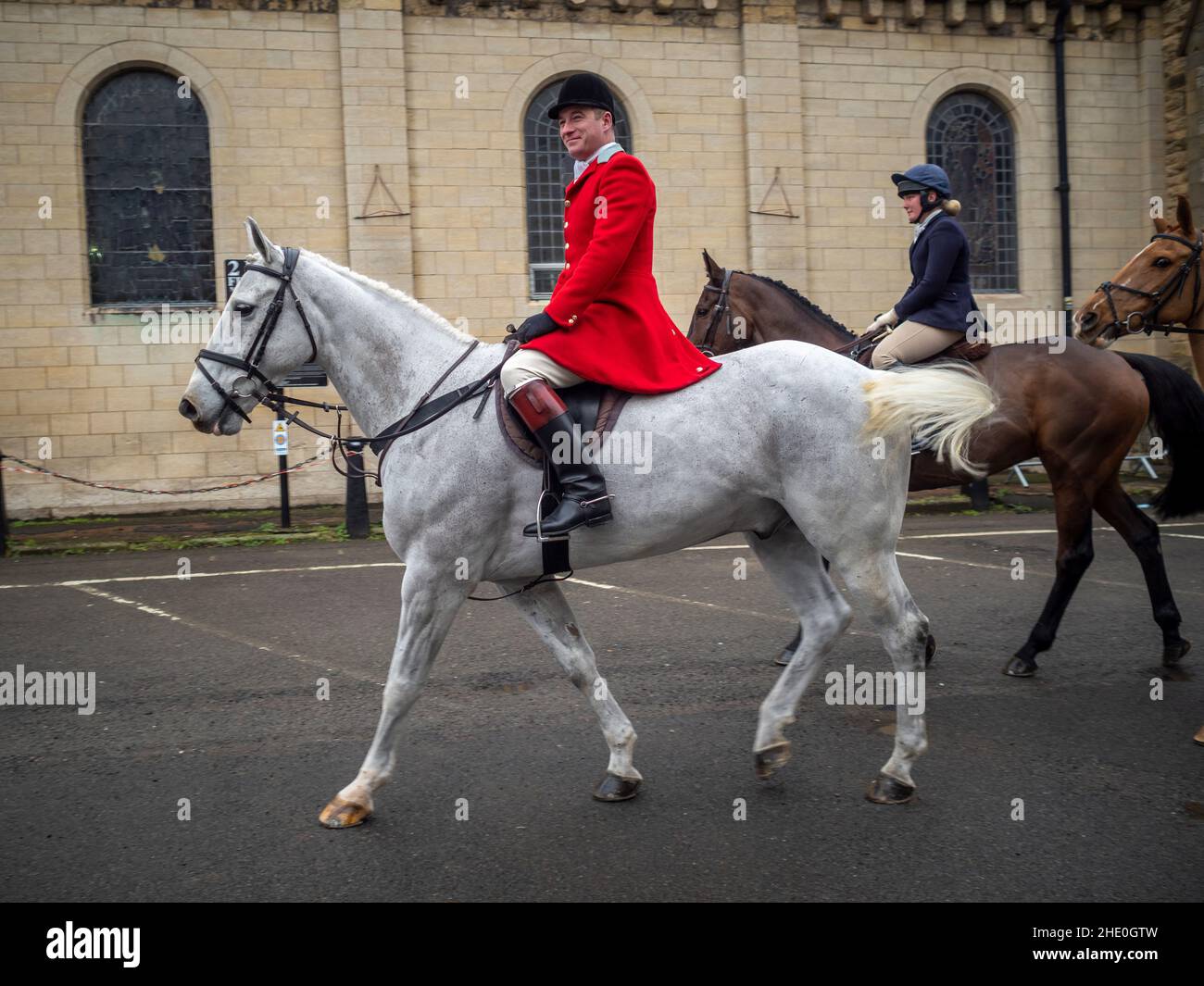 Huntsman wearing traditional red jacket ready for the Middleton boxing day fox hunt, riding a white horse. Malton. Stock Photo