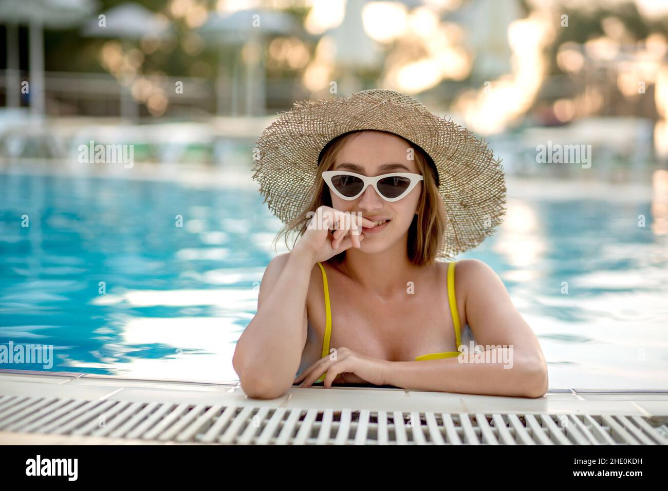 Beautiful woman in a hat and sunglasses relaxing in the pool Stock ...