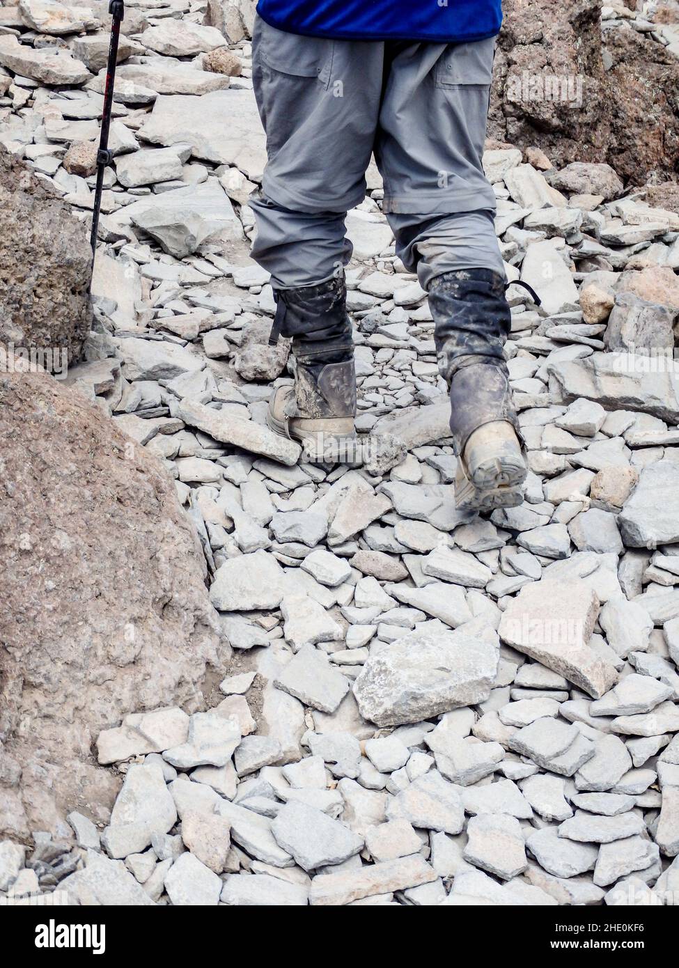 Hiking in boots on rocky slope from waist down Stock Photo Alamy