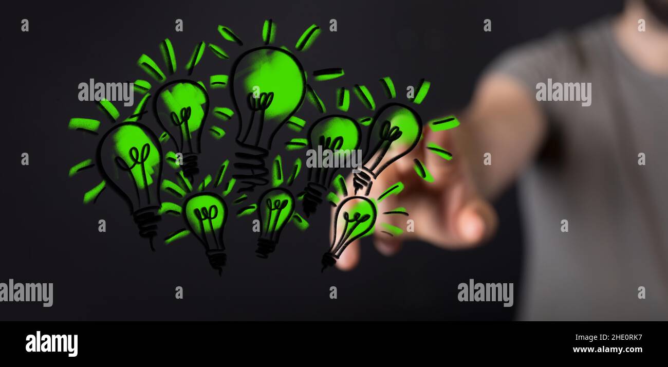 Male pointing to an illustration of green light bulbs - eco-friendly business Stock Photo