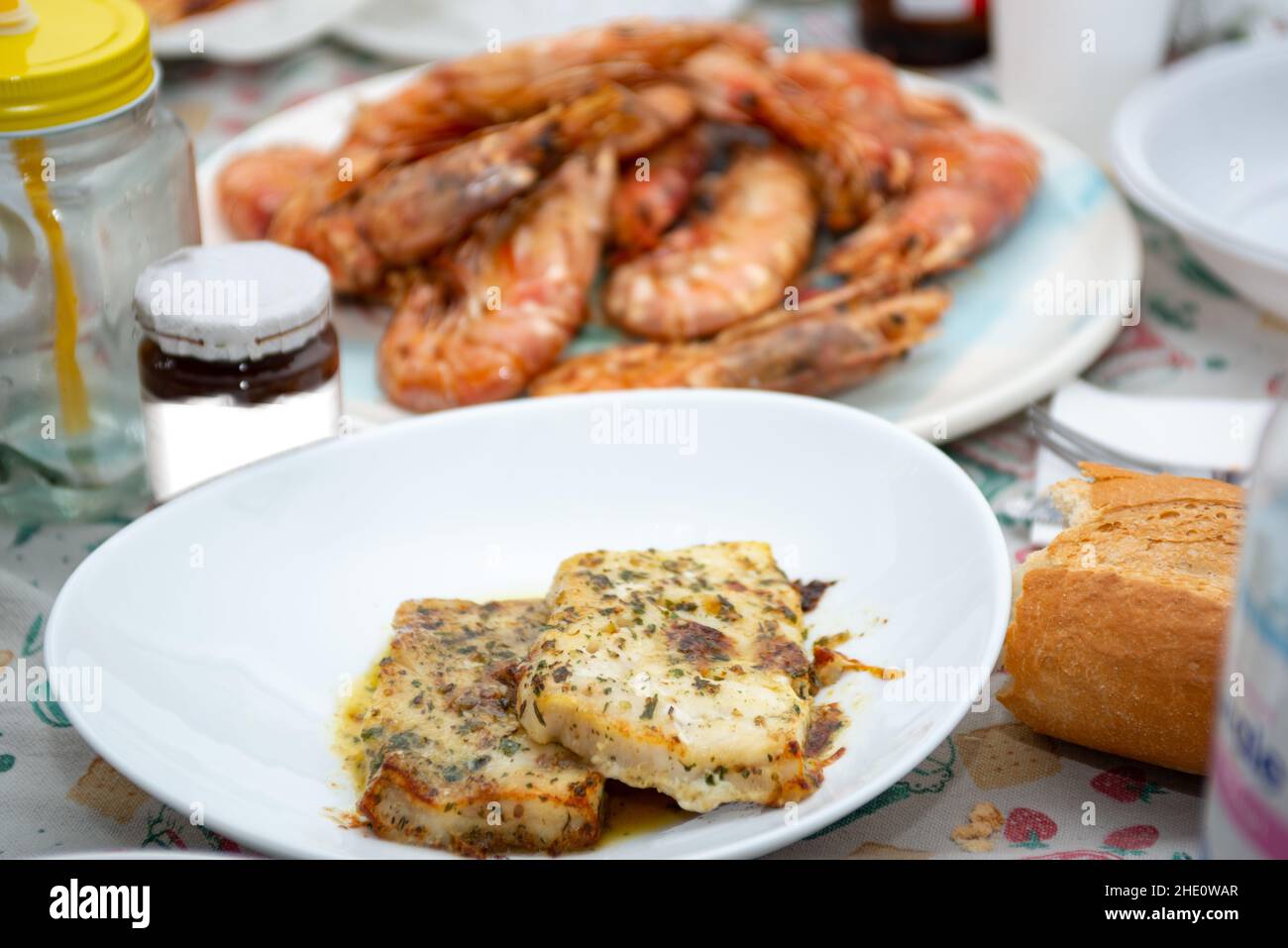 fried king prawns and cod fillet on plate closeup Stock Photo