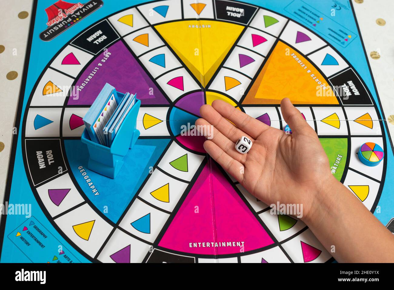 Playing Trivial  pursuit board game at home during Covid-19 lockdown,- dice in palm London,UK Stock Photo