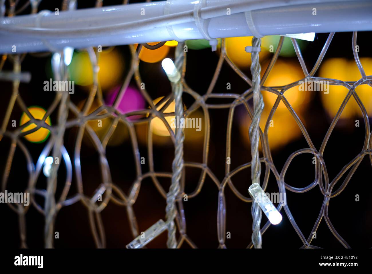 Some white decoration light bulbs web close up still with some colourful blurred spots on a black background Stock Photo