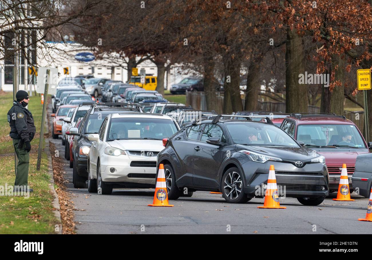 Wilkes-Barre, Pennsylvania, USA. 6th Jan, 2022. A sheriffs deputy stands at a merge point of the drive thru test site for those waiting to be tested for Covid-19. The line was between 3-5 hours.With the new Omicron variant Covid-19 surge, testing sites are seeing long lines for testing. Employees from AMI Expeditionary Healthcare are seen in Pennsylvania giving Covid-19 tests. The group has been moving from hotel to hotel and working 12 hour days, 4-5 days a week to test community members for Covid-19. (Credit Image: © Aimee Dilger/SOPA Images via ZUMA Press Wire) Stock Photo