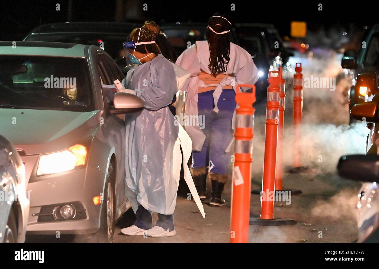 Wilkes-Barre, Pennsylvania, USA. 6th Jan, 2022. Healthcare workers wearing Personal Protective Equipment (PPE) gears collect nasal swab samples from people at a drive thru test site.With the new Omicron variant Covid-19 surge, testing sites are seeing long lines for testing. Employees from AMI Expeditionary Healthcare are seen in Pennsylvania giving Covid-19 tests. The group has been moving from hotel to hotel and working 12 hour days, 4-5 days a week to test community members for Covid-19. (Credit Image: © Aimee Dilger/SOPA Images via ZUMA Press Wire) Stock Photo