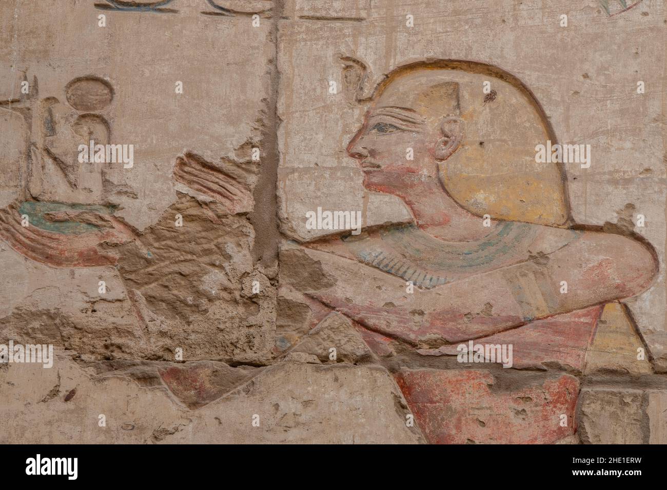 A remarkably well preserved painted relief sculpture of a pharaoh on a temple wall in Karnak temple, an archeological site in Egypt. Stock Photo