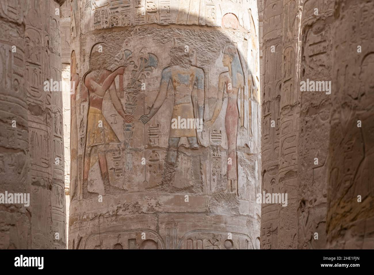 Figures in the Hypostyle hall at Karnak temple, the relief sculptures are well preserved even retaining paint although the faces were chipped off. Stock Photo