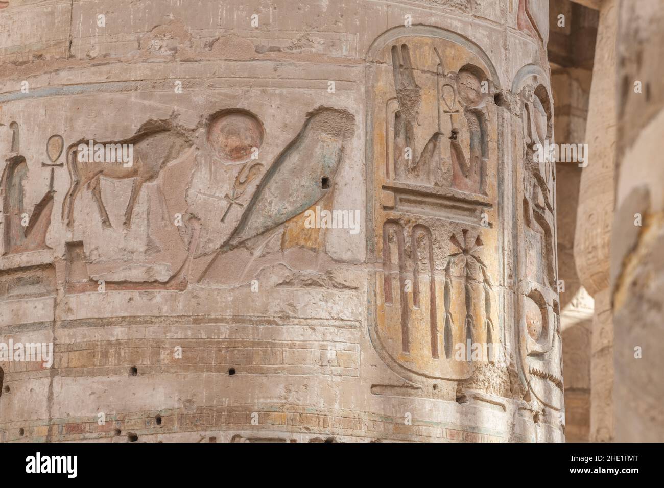 Figures in the Hypostyle hall at Karnak temple, the relief sculptures are well preserved even retaining paint although the faces were chipped off. Stock Photo