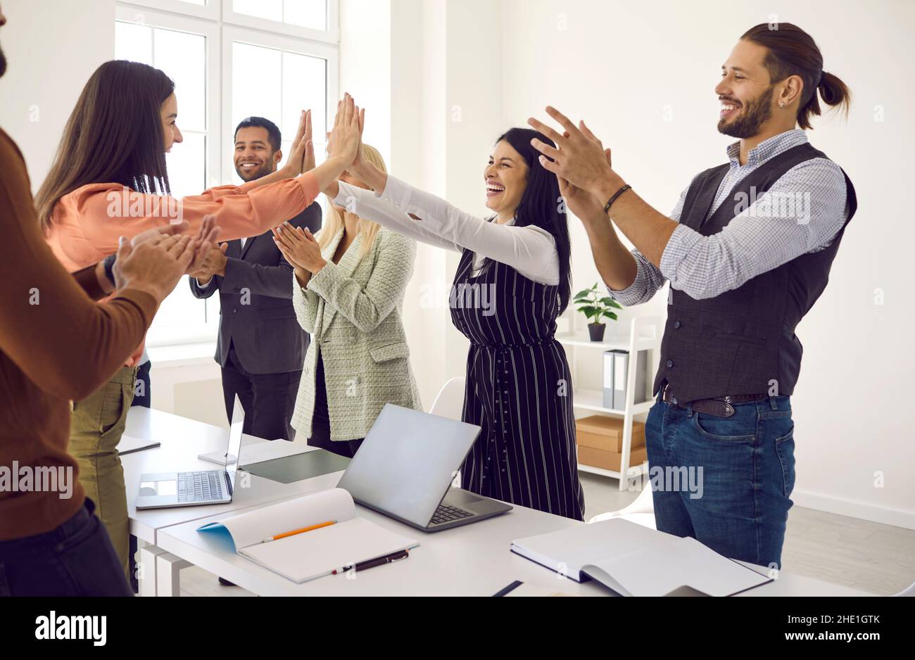 Happy business women giving each other high five while diverse ...