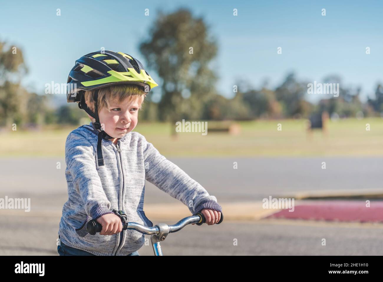 Portrait of a child wearing a helmet while riding his balance bike on