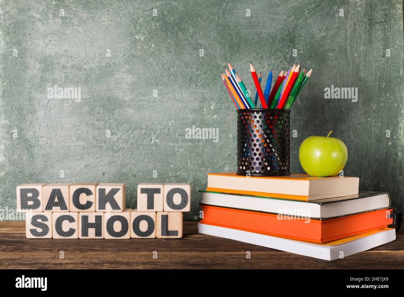 Stack of books and stationery and slogan back to school on the