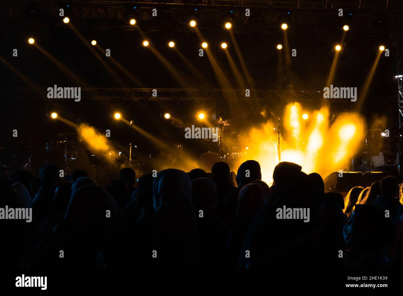Concert background. Yellow spotlights on the stage and silhouette of