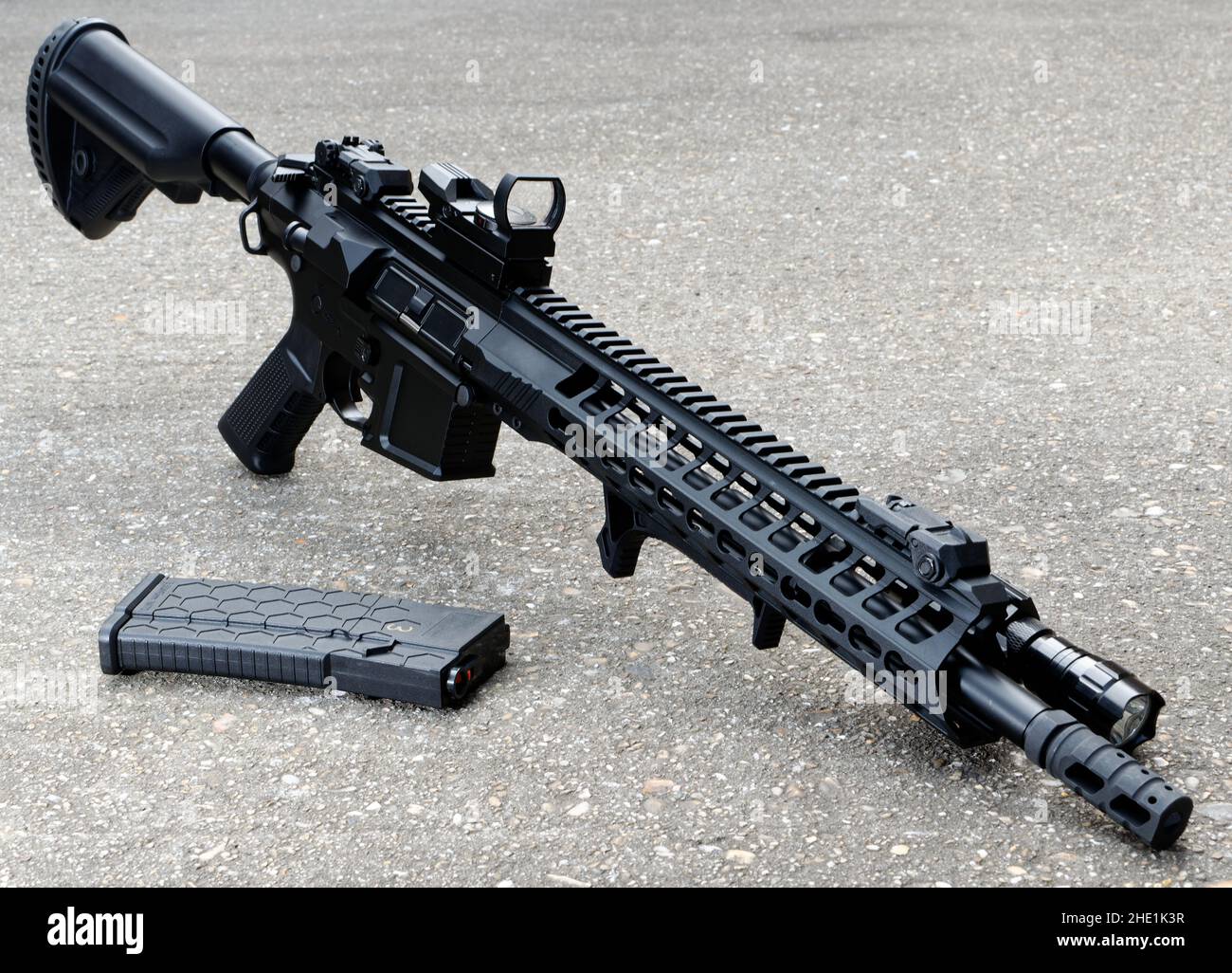 Airsoft replica M4-M16 style rifle, freestanding on concrete. Stock Photo