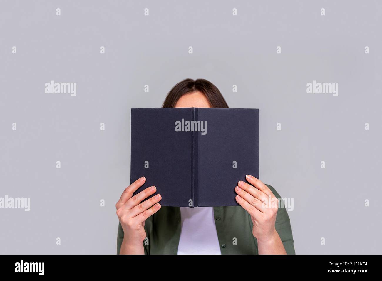 Caucasian unrecognizable woman hiding behind day planner.  Stock Photo