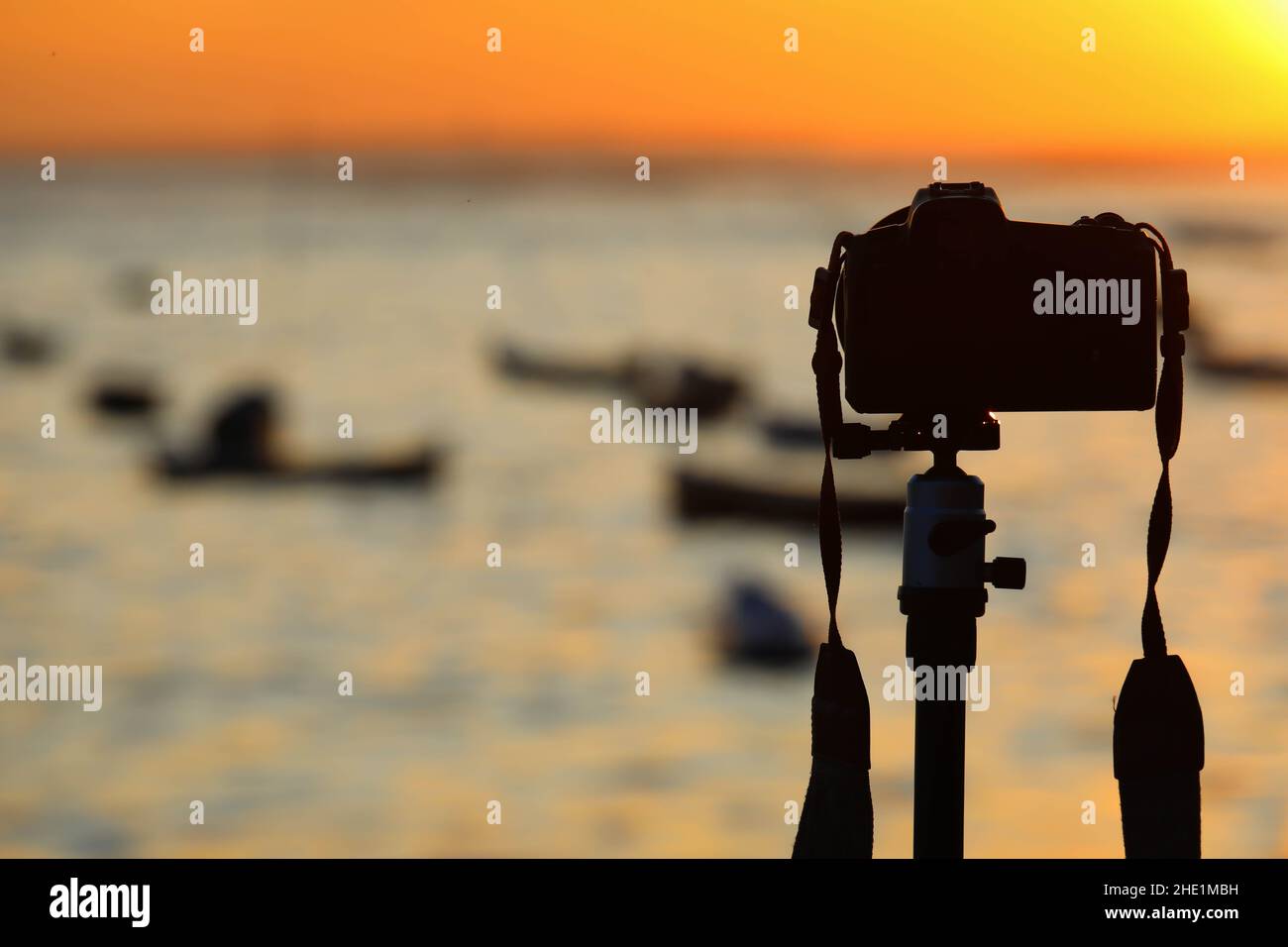 Camera on tripod take photo from sunrise over sea Stock Photo - Alamy