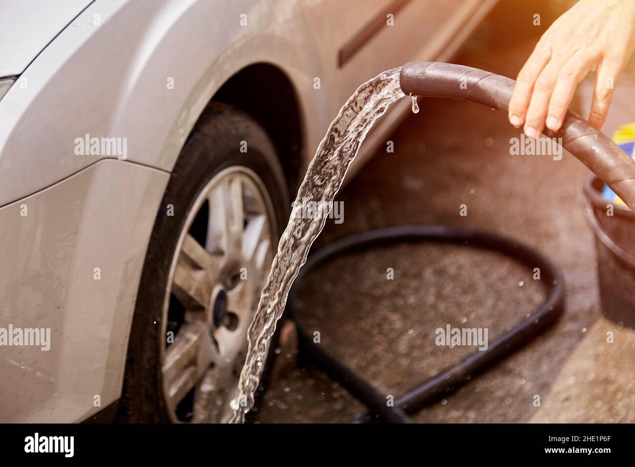 Washing the car with water from under the hoses. Home routines. Caring