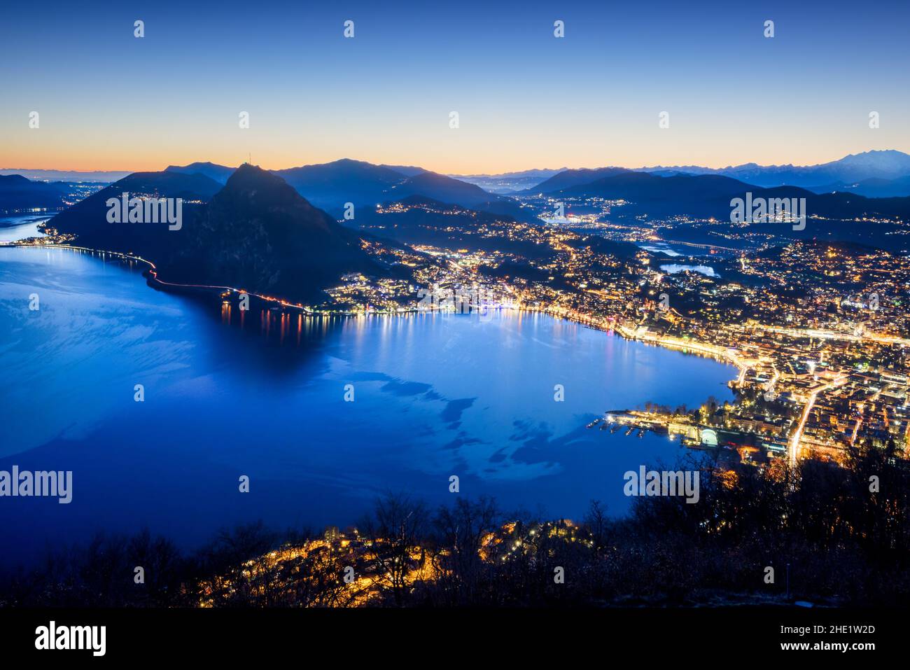 Night view of Lugano city on Lake Lugano in the Alps mountains, Switzerland Stock Photo