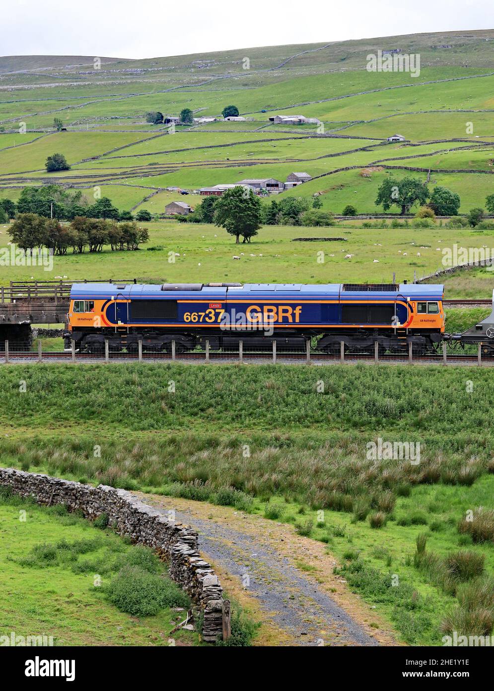 GBRF diesel locomotive no 66737 waits at Arcow quarry near Helwith Bridge in the Yorkshire Dales while it’s train is loaded with stone. Stock Photo
