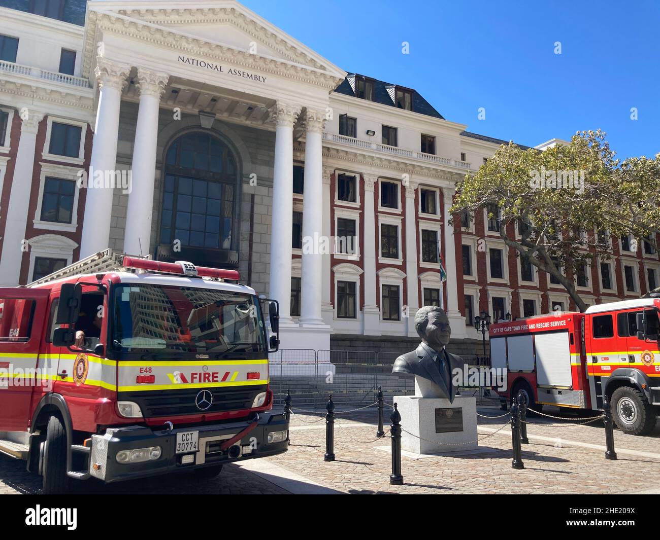 Burnt out South African parliament after a fire, with Mandela statue Stock Photo