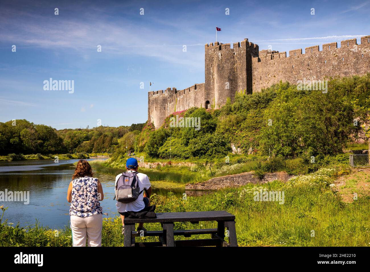 UK, Wales, Pembrokeshire, Pembroke, visitors on picnic table below walls of Castle Stock Photo