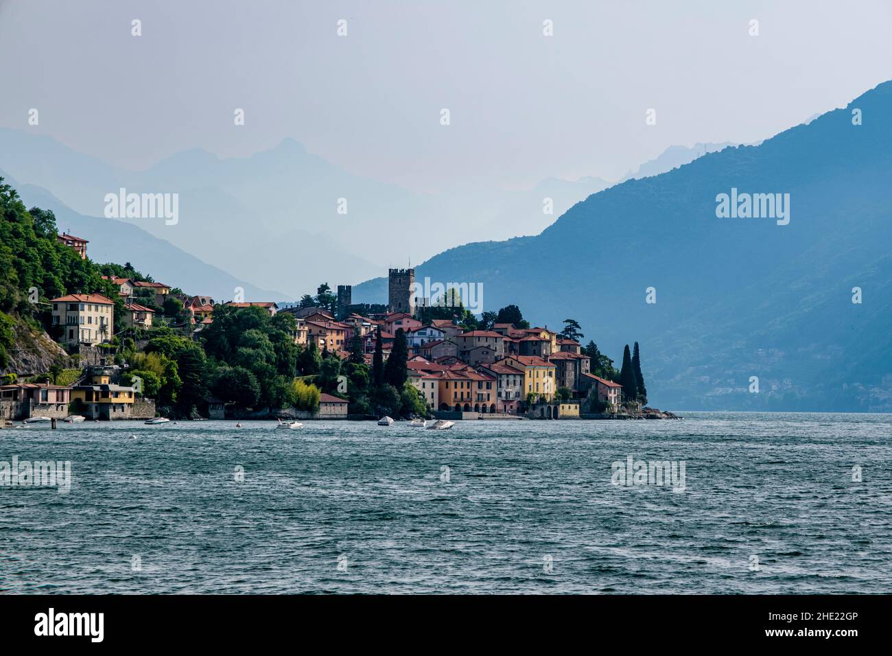 View of the lakeside of town, including the Castello di Rezzonico, across Lake Como from a ferryboat. Stock Photo