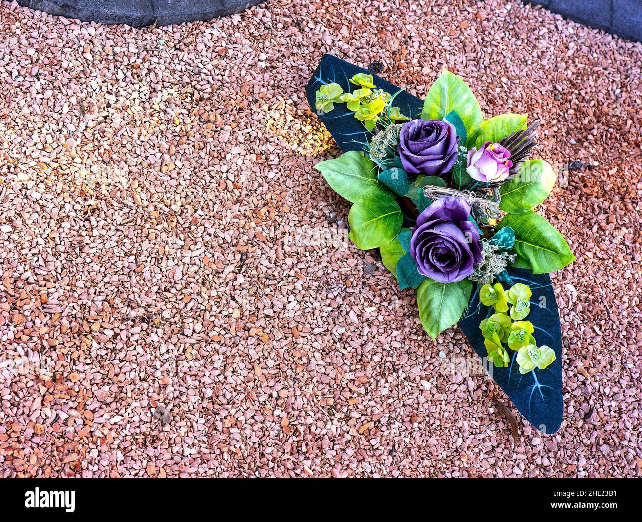 Array of flowers on top of a grave in the winter time. Stock Photo