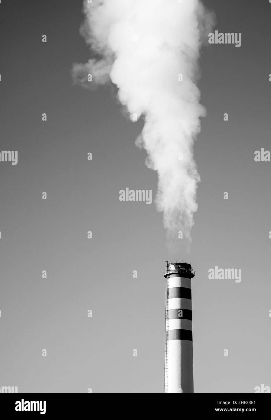 Industrial chimney producing carbon imprint around in the sky, Stock Photo