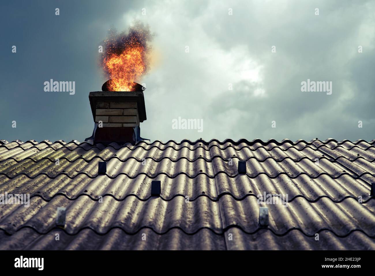 Chimney is on fire in a dramatic scene with clouds. Stock Photo
