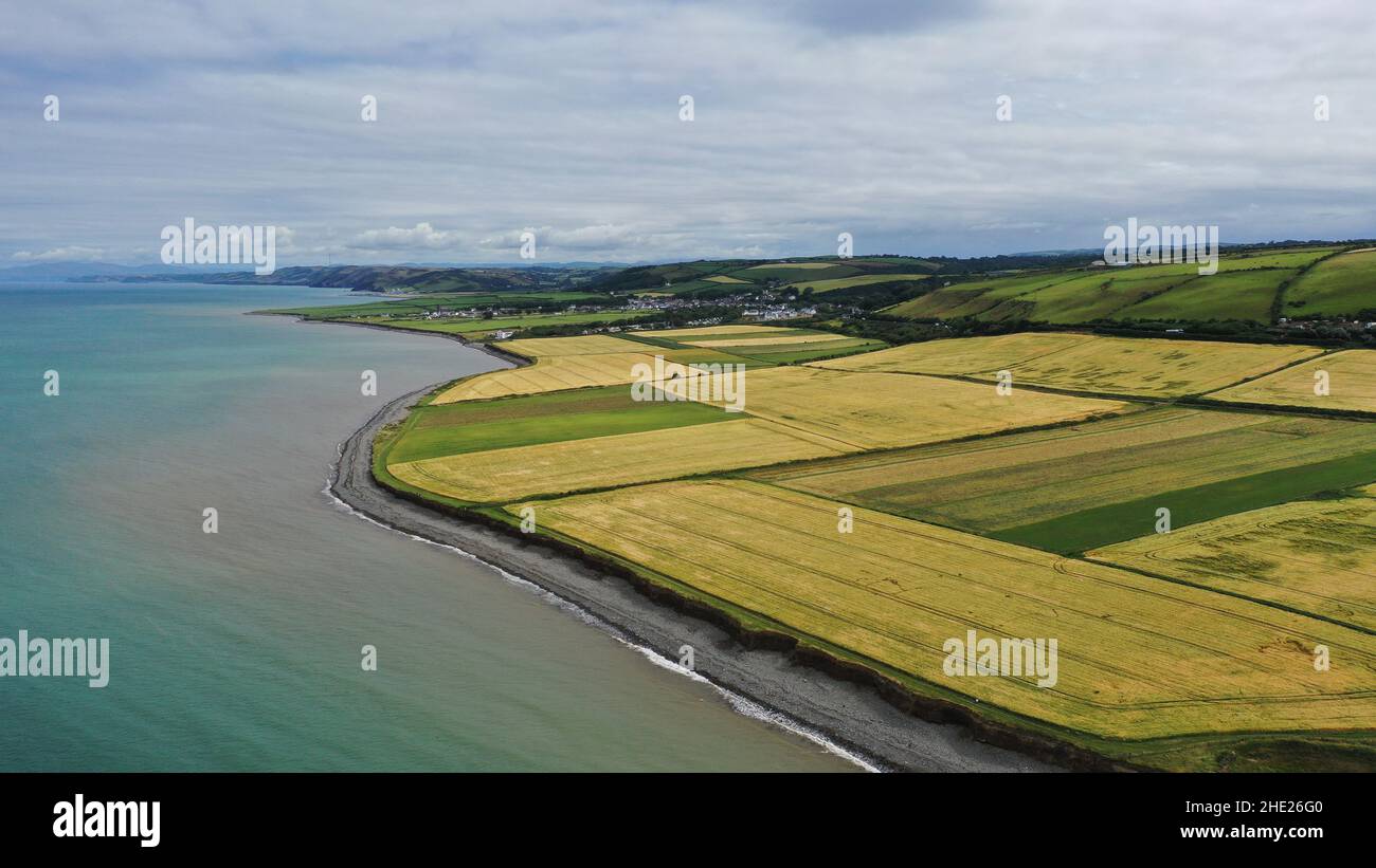 Aerial image looking over fields to the village of Llanon, showing the beach, fields and sea with further views. Stock Photo