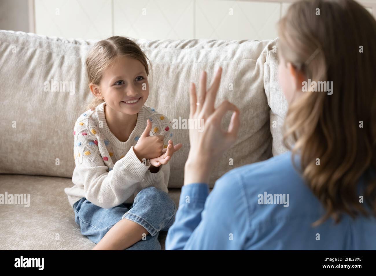 Happy little kid using sign language, communicating with mother. Stock Photo