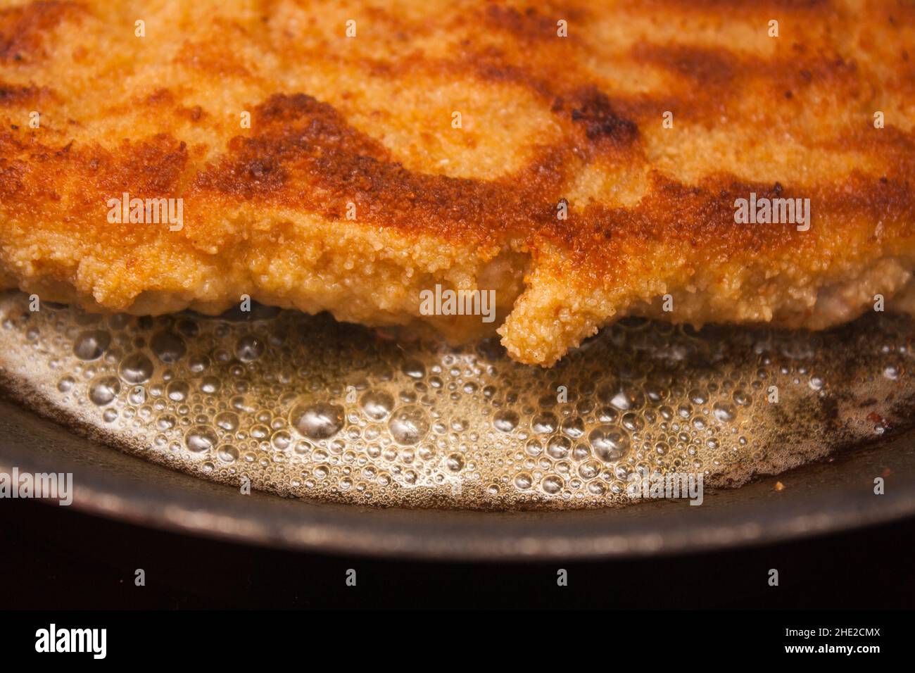 Roasting a wiener schnitzel in a black pan Stock Photo Alamy