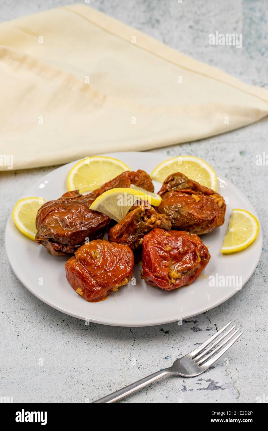 Dried stuffed peppers on a stone background. Rice stuffed sundried red pepper. Turkish cuisine appetizers. Kuru biber dolması. Vertical view. close up Stock Photo