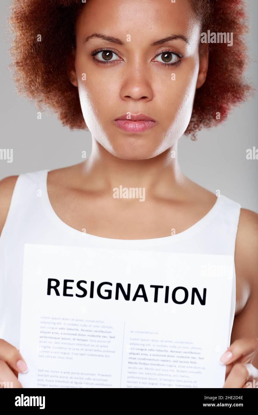 Serious young Black woman tendering her resignation holding up a printed sign in a cropped portrait Stock Photo