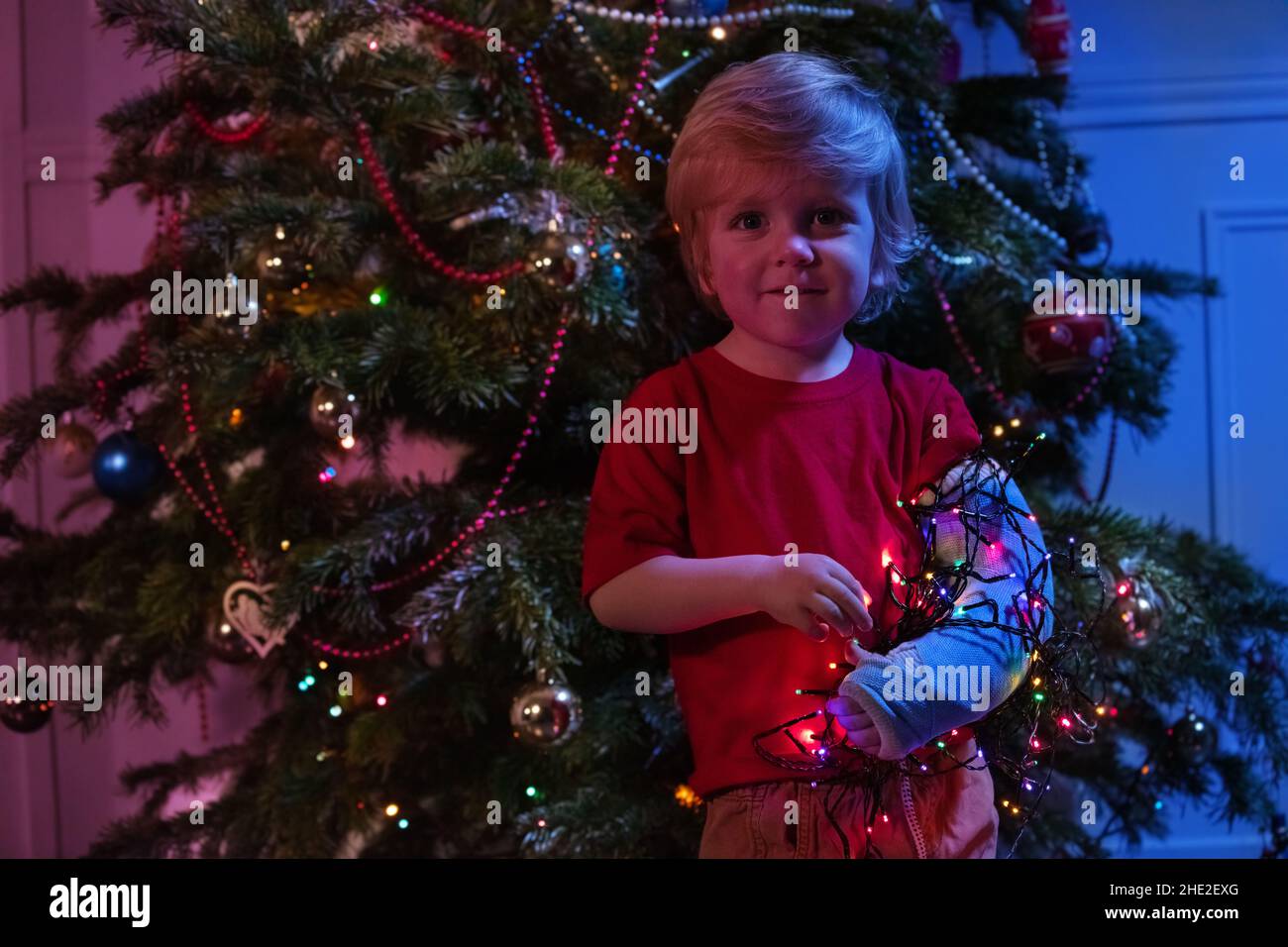 Child's broken hand in a cast and Christmas lights Stock Photo