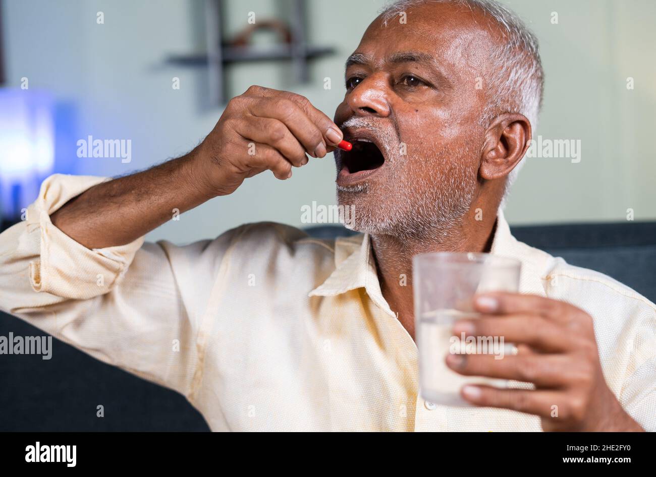 Alone Sick old man taking medicines at home - concept of unhealthy senior people on medication and Healthcare Stock Photo