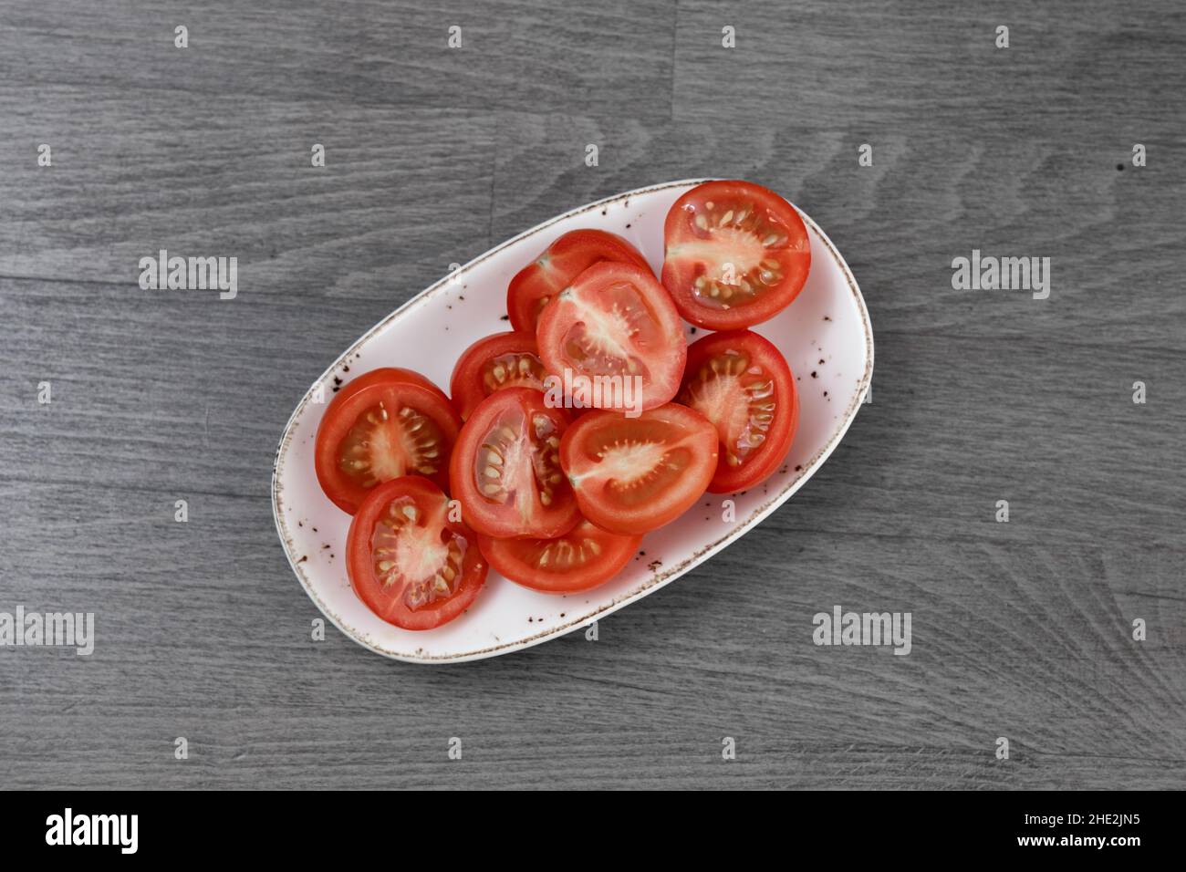 sliced tomatoes on wooden table Stock Photo