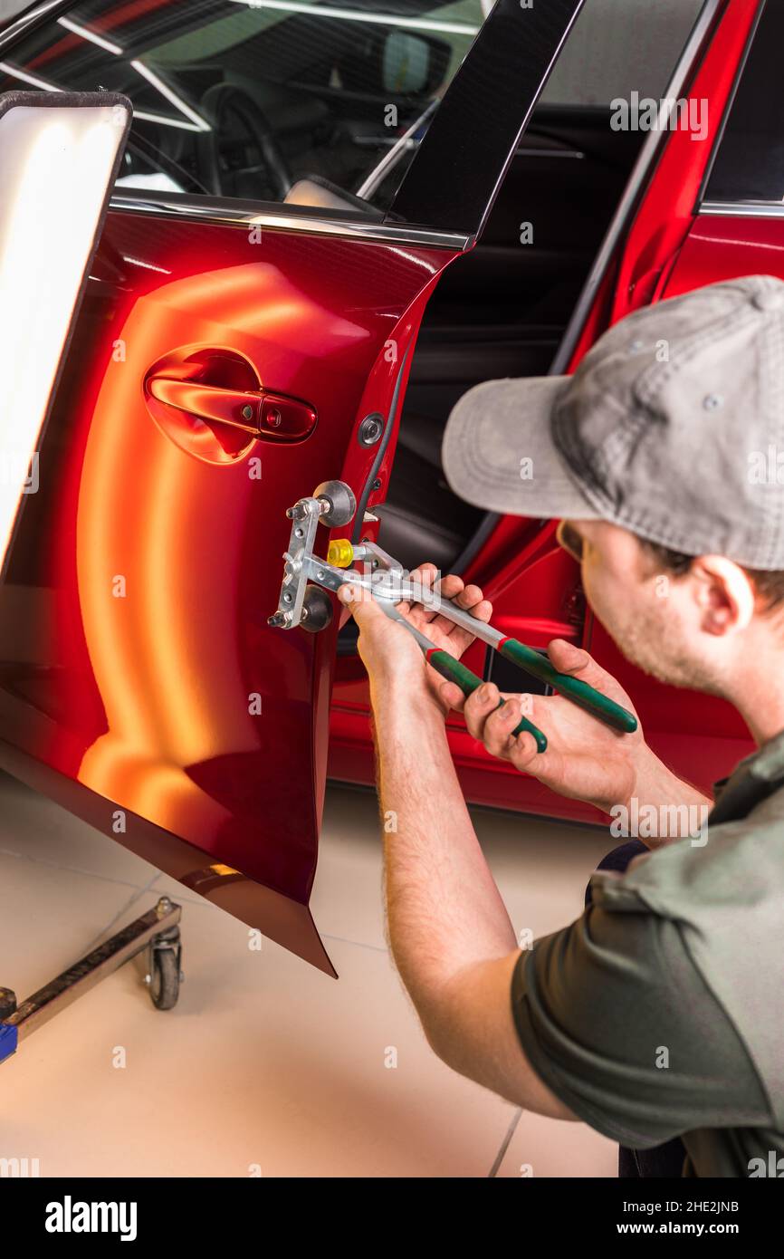 Removing dents on a car body without painting. PDR. Stock Photo