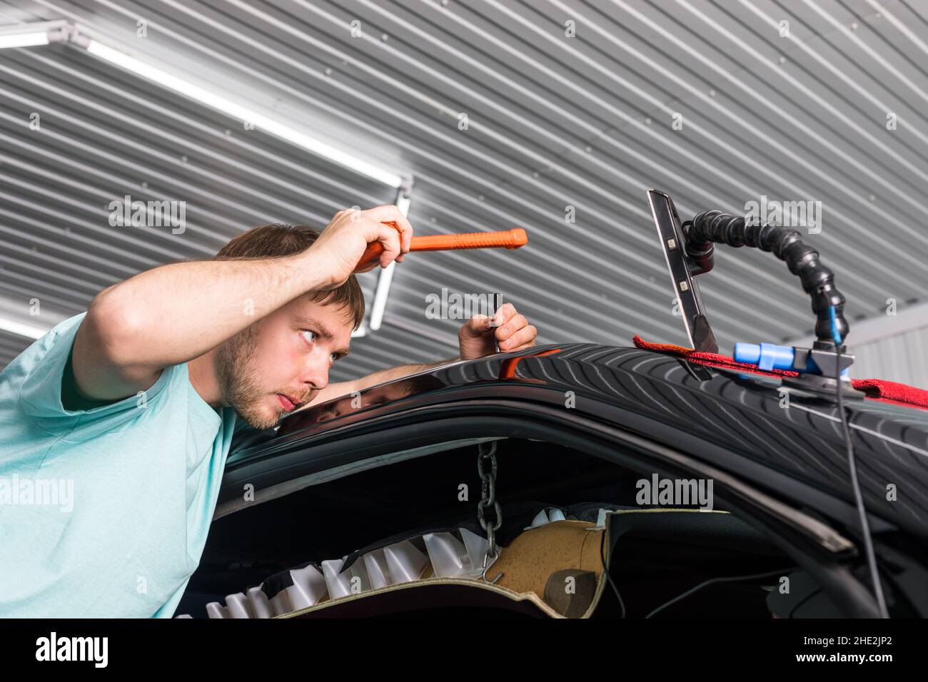 Removing dents on a car body without painting. PDR. Stock Photo