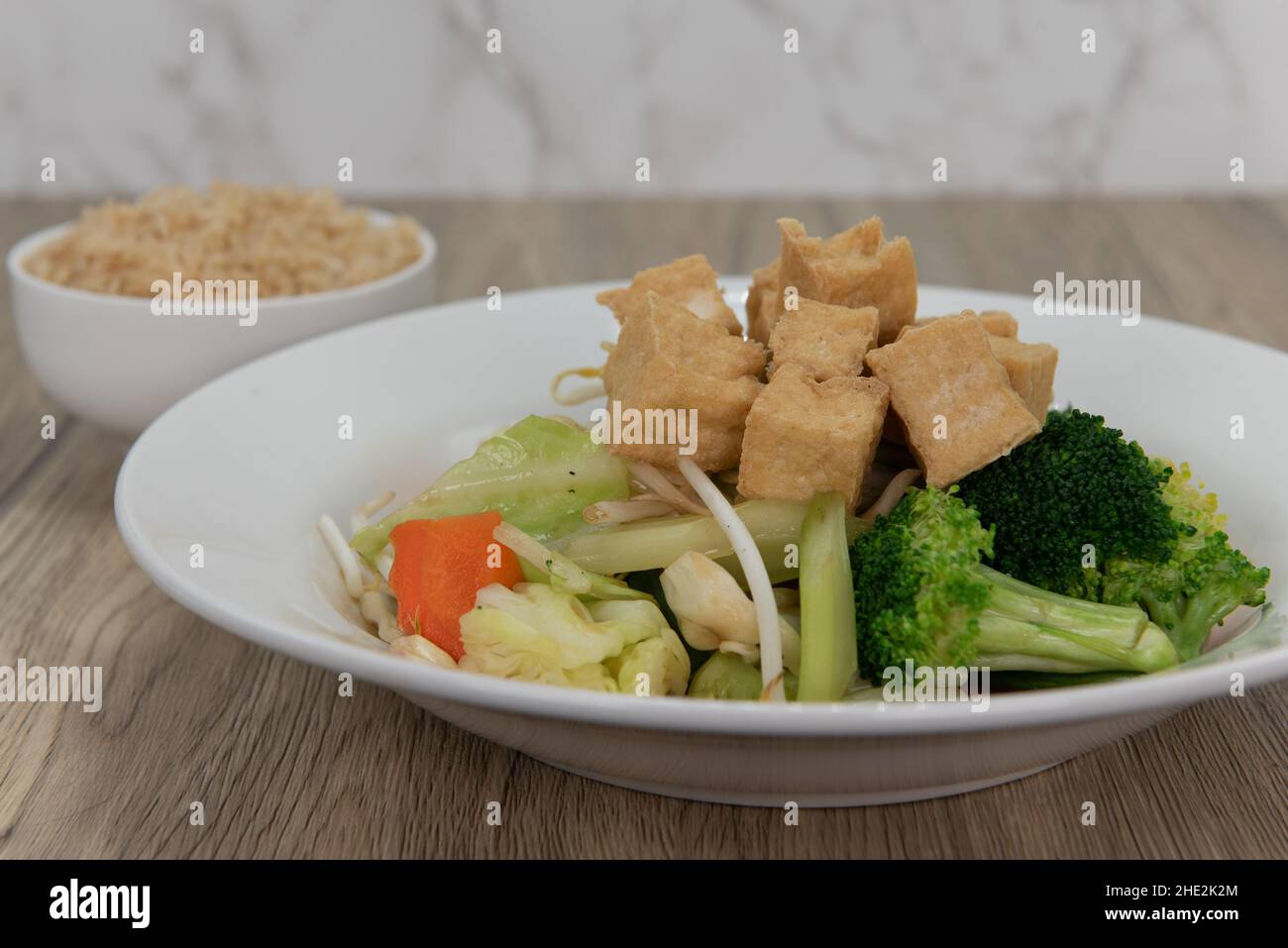 Breaded orange chicken crispy on the outside with sliced citrus twist on top of generous pile of food. Stock Photo
