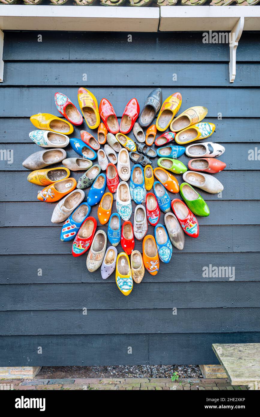 Decoratively painted Dutch clogs in the shape of a heart on the wall of a wooden shed. Stock Photo